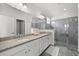 Bright bathroom featuring a double sink vanity with granite countertops and a glass-enclosed shower at 16176 Lotus Way, Punta Gorda, FL 33982