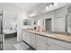 Well-lit bathroom featuring double sinks with granite countertops and a shower with glass door at 16176 Lotus Way, Punta Gorda, FL 33982
