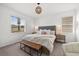 Bright bedroom with a large bed, upholstered headboard, woven light fixture, and view to the outdoors at 16176 Lotus Way, Punta Gorda, FL 33982