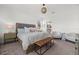 Bright bedroom with a large bed, upholstered headboard, woven light fixture, and seating area at 16176 Lotus Way, Punta Gorda, FL 33982