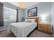 Comfortable bedroom with soft blue walls and ample light from the large window at 16176 Lotus Way, Punta Gorda, FL 33982