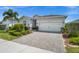 Beautiful single-story home showcasing a paver driveway, two-car garage, and lush landscaping at 16176 Lotus Way, Punta Gorda, FL 33982