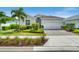 Charming single-story home featuring a well-manicured lawn, tropical landscaping, and a paver driveway at 16176 Lotus Way, Punta Gorda, FL 33982