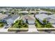 Front aerial view of a beautifully landscaped property with lush greenery and a well-maintained lawn at 16176 Lotus Way, Punta Gorda, FL 33982