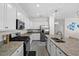 Modern kitchen featuring white cabinets, stainless steel appliances, and granite countertops and island at 16176 Lotus Way, Punta Gorda, FL 33982