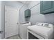 A functional laundry room with modern washer and dryer units, overhead cabinets at 16176 Lotus Way, Punta Gorda, FL 33982