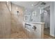 Close-up of modern bathroom boasts glass-enclosed shower with stone floor and tile walls at 1721 Walden Ct, Englewood, FL 34224