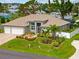 Well-maintained single-story home with lush landscaping, a three-car garage, and a charming front seating area at 1721 Walden Ct, Englewood, FL 34224