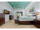 Bright main bedroom boasts a tray ceiling, natural light, and wood-look floors at 1721 Walden Ct, Englewood, FL 34224