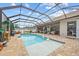Screened-in pool area with stone pavers, swan decoration, and comfortable seating perfect for outdoor relaxation at 1721 Walden Ct, Englewood, FL 34224