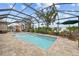 Screened-in pool area with lounge chairs and tropical landscaping, creating a private backyard oasis at 1721 Walden Ct, Englewood, FL 34224