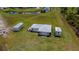 Aerial shot of a property with a building, open space, and parked trailers surrounded by lush greenery at 17400 White Water Ct, Punta Gorda, FL 33982