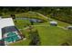 Aerial view of home and grounds featuring pool, pond, gazebo and lush landscaping at 17400 White Water Ct, Punta Gorda, FL 33982