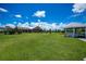 Expansive backyard featuring a gazebo, lush lawn, and screened lanai overlooking a tranquil setting at 17400 White Water Ct, Punta Gorda, FL 33982