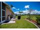 Expansive backyard featuring lush green grass, a sprinkler system, and a glimpse of the pool in the distance at 17400 White Water Ct, Punta Gorda, FL 33982