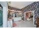 A bathroom featuring dual sinks, marble counters, patterned wallpaper, and an open doorway at 17400 White Water Ct, Punta Gorda, FL 33982