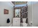 A powder room with patterned wallpaper, white vanity, toilet, and framed mirror at 17400 White Water Ct, Punta Gorda, FL 33982