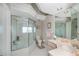 A bright bathroom featuring a glass enclosed tub/shower combination and patterned walls at 17400 White Water Ct, Punta Gorda, FL 33982