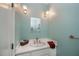 A powder room featuring a white vanity, brass fixtures, and light blue walls at 17400 White Water Ct, Punta Gorda, FL 33982