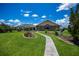 Screened lanai and landscaped pathway leading to home, with a sprawling green lawn at 17400 White Water Ct, Punta Gorda, FL 33982