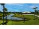 Beautiful single-Gathering home with expansive lawn and pond views, framed by mature palm trees at 17400 White Water Ct, Punta Gorda, FL 33982