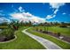 Scenic view of a white gazebo at the end of a winding pathway through a lush, landscaped garden at 17400 White Water Ct, Punta Gorda, FL 33982