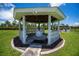 A charming white gazebo with seating and a center table offers a tranquil outdoor retreat with scenic views at 17400 White Water Ct, Punta Gorda, FL 33982