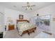 Bright main bedroom with ceiling fan, sliding glass doors, and a wood-framed bed with green leafy bedding at 17400 White Water Ct, Punta Gorda, FL 33982