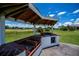 Outdoor kitchen features a brick grill, countertop, and sink under a wooden pergola, perfect for entertaining at 17400 White Water Ct, Punta Gorda, FL 33982