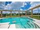 Inviting screened-in pool area with in-pool seating and scenic views of the surrounding landscape at 17400 White Water Ct, Punta Gorda, FL 33982