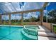 Covered lanai featuring spa, pool and view of backyard at 17400 White Water Ct, Punta Gorda, FL 33982