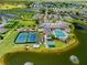 Aerial view of community clubhouse with pool, tennis, bocce ball, shuffleboard, and well-manicured landscaping at 1812 Birmingham Blvd, Punta Gorda, FL 33980