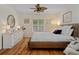 Comfortable bedroom with hardwood floors, a ceiling fan, a white dresser and plantation shutters for bright light at 1812 Birmingham Blvd, Punta Gorda, FL 33980