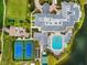 Aerial view of the community clubhouse featuring a swimming pool, tennis courts, and ample parking at 1812 Birmingham Blvd, Punta Gorda, FL 33980