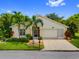 Charming single-story home with well-manicured lawn, mature palm trees, and a two-car garage at 1812 Birmingham Blvd, Punta Gorda, FL 33980