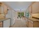 Well-lit kitchen with white appliances and beautiful cabinetry leading to dining area with picturesque backyard view at 1812 Birmingham Blvd, Punta Gorda, FL 33980