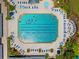 Aerial view of community swimming pool with lounge chairs, tables and umbrellas for shade, and mature landscaping at 1812 Birmingham Blvd, Punta Gorda, FL 33980