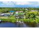 Aerial view of home with a pool, dock, and waterfront access, surrounded by lush greenery at 18585 Klingler Cir, Port Charlotte, FL 33948