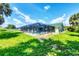 Lush backyard features screened-in pool and peaceful outdoor living space at 18585 Klingler Cir, Port Charlotte, FL 33948