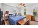 Bedroom featuring a ceiling fan, two windows, and a bed with blue striped bedding at 18585 Klingler Cir, Port Charlotte, FL 33948