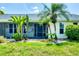 Charming home exterior with lush landscaping, a screened porch and tropical plants at 18585 Klingler Cir, Port Charlotte, FL 33948