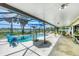 Inviting screened-in pool area overlooking the serene water views, perfect for relaxation and entertaining at 18585 Klingler Cir, Port Charlotte, FL 33948