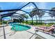 Inviting screened pool surrounded by tropical landscaping and sun loungers at 18585 Klingler Cir, Port Charlotte, FL 33948