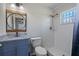 Bathroom with granite vanity, round mirror and tub with shower at 2101 W Cherry St, Tampa, FL 33607
