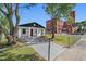 Charming home with red front door, white paint, new sidewalk and an adjacent brick building at 2101 W Cherry St, Tampa, FL 33607