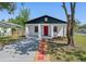 Charming single-story home with a red door, gray driveway, and fresh landscaping in a fenced yard at 2101 W Cherry St, Tampa, FL 33607