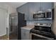 Kitchen featuring stainless steel appliances, gray cabinets, and stone backsplash at 2101 W Cherry St, Tampa, FL 33607