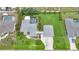 Aerial view of a property with a pool, spacious lawn, and detached two-car garage at 23493 Taber Ave, Port Charlotte, FL 33954