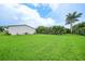 Large backyard with manicured green grass and tropical landscaping at 23493 Taber Ave, Port Charlotte, FL 33954