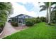 Expansive backyard featuring lush landscaping, brick pavers and a screened-in lanai at 23493 Taber Ave, Port Charlotte, FL 33954